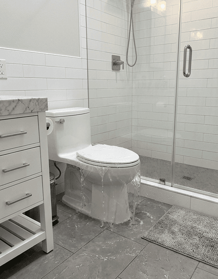 Flooded bathroom — water on the floor around toilet and shower