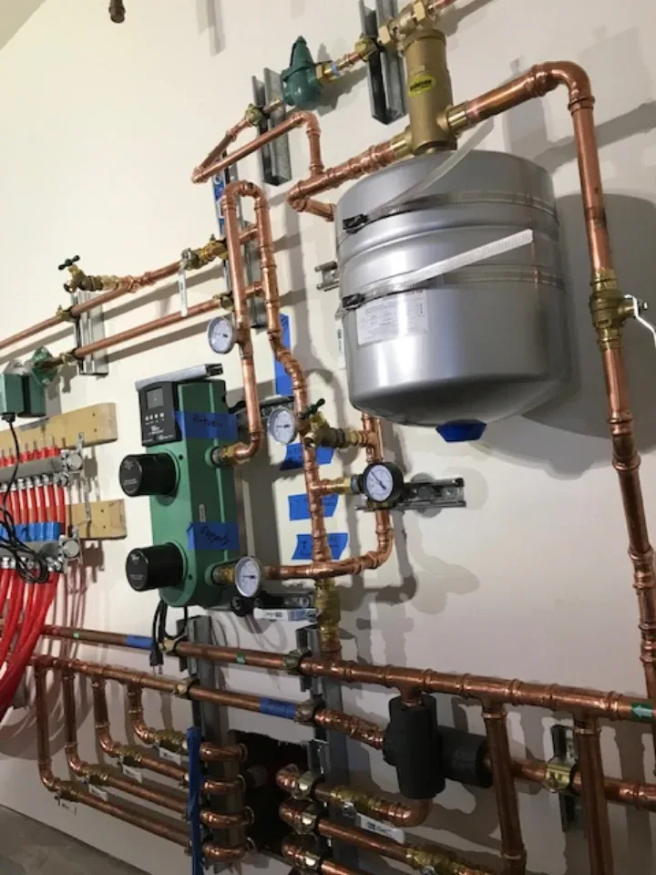 Hydronic mechanical room — expansion tank and circulators installed by Guerra Bros.