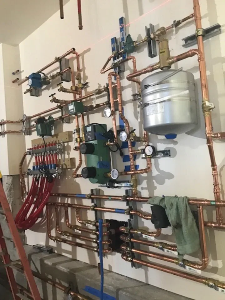 Full hydronic system wall installation with copper pipes and circulators